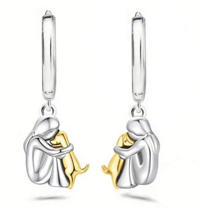 A little girl and a dog embrace earrings